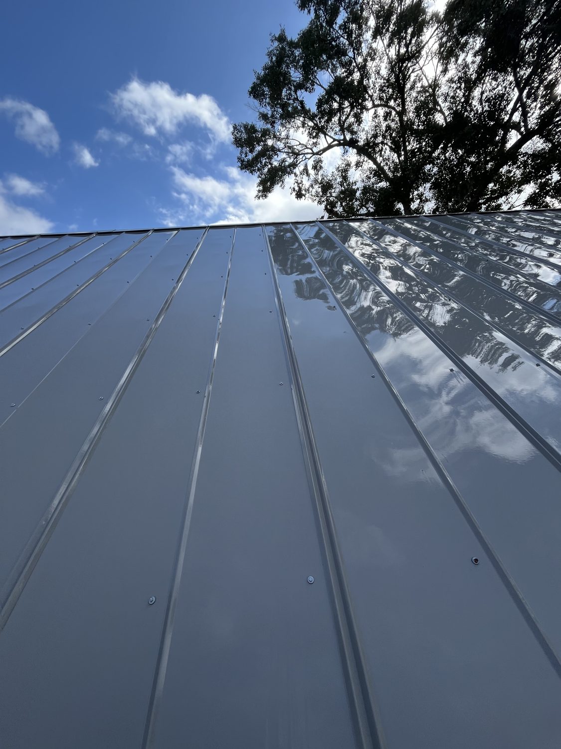 The same roof after SMRW's soft wash — mirror finish reflecting the sky