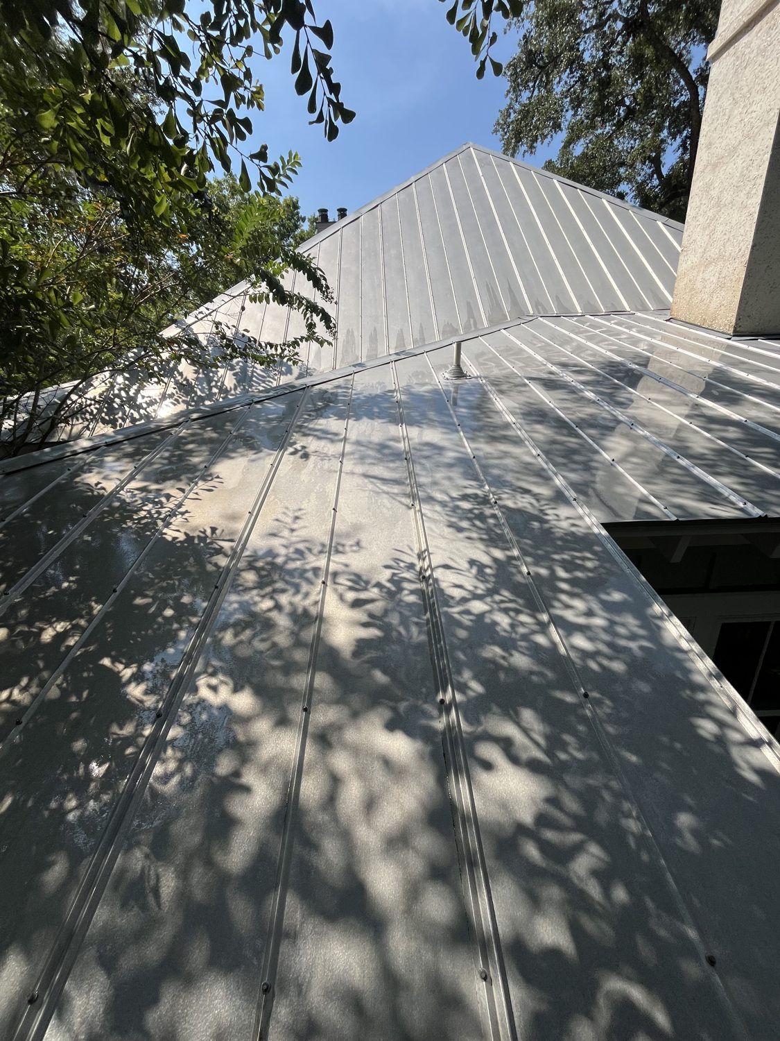 The same roof, same angle, cleaned back to bare bright metal