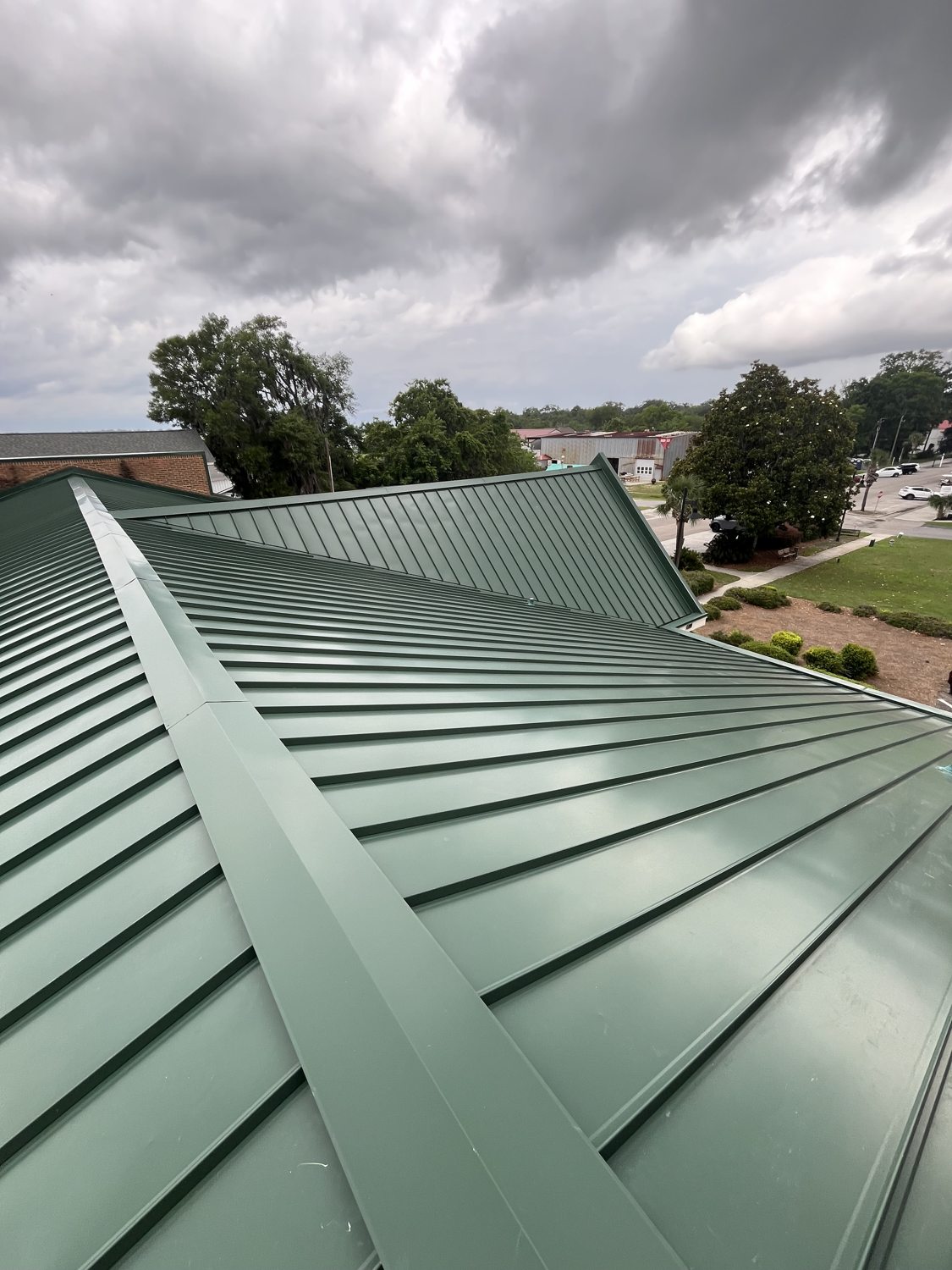 Large commercial metal roof cleaned end to end, overlooking the property below