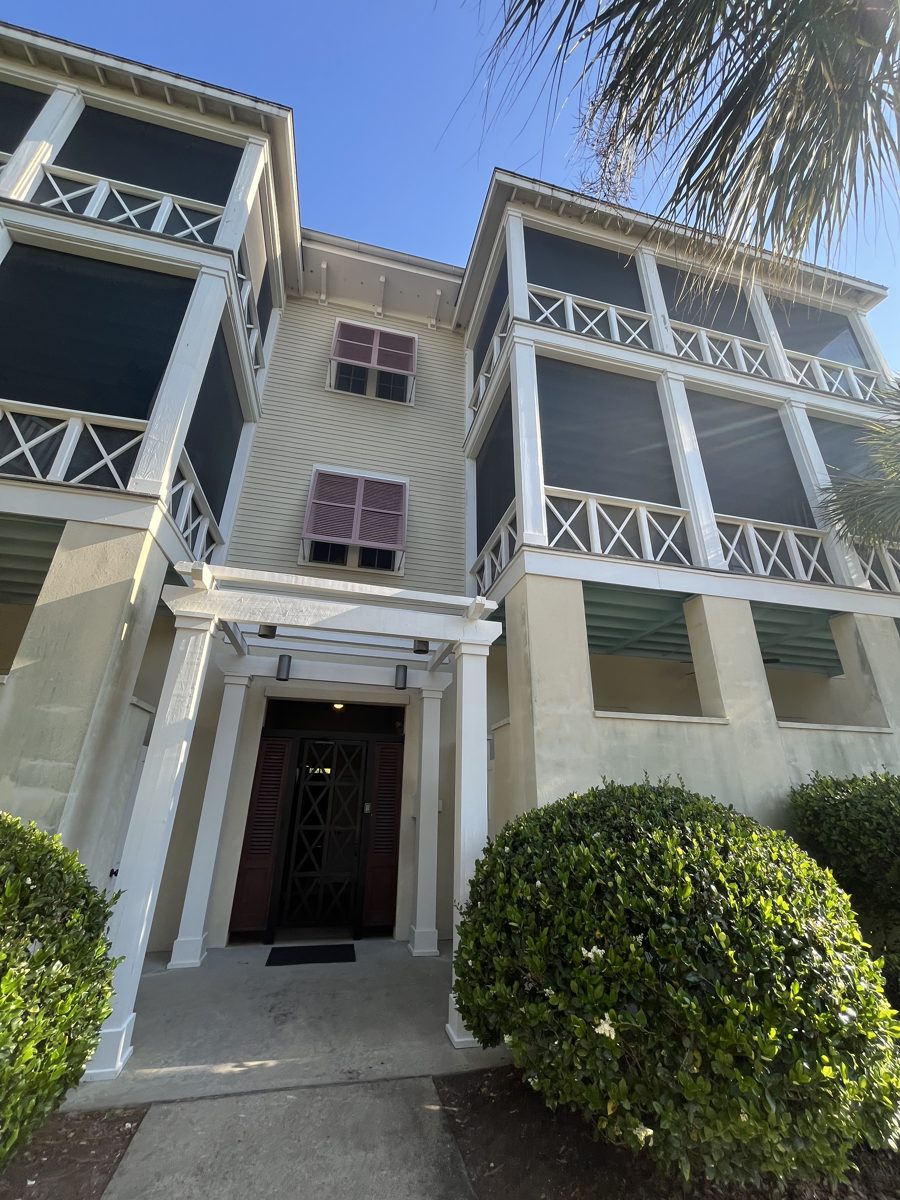 Multi-story building entrance and porches after a full exterior wash