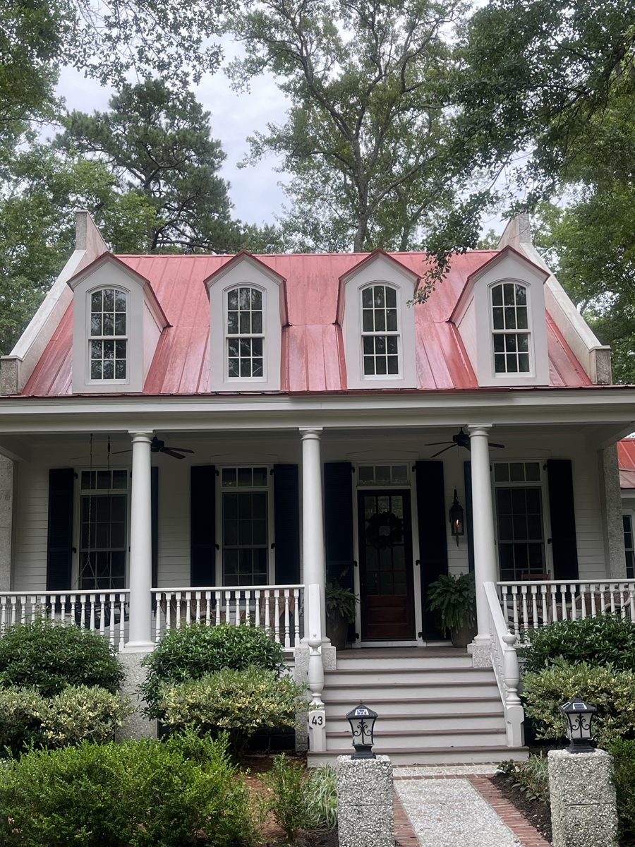 Historic Lowcountry home with a freshly cleaned salmon metal roof and dormers