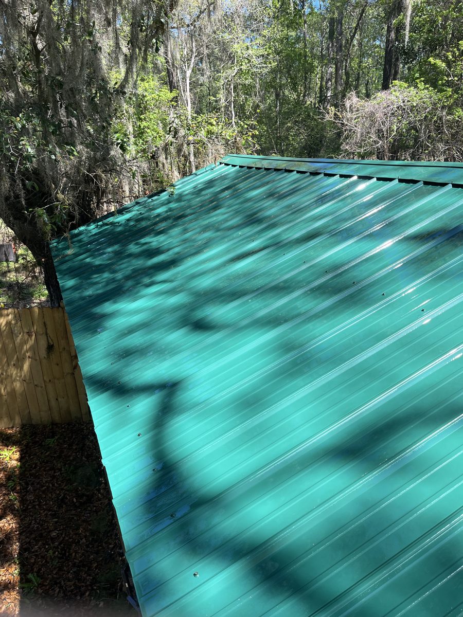 Teal metal roof cleaned to an even, bright finish