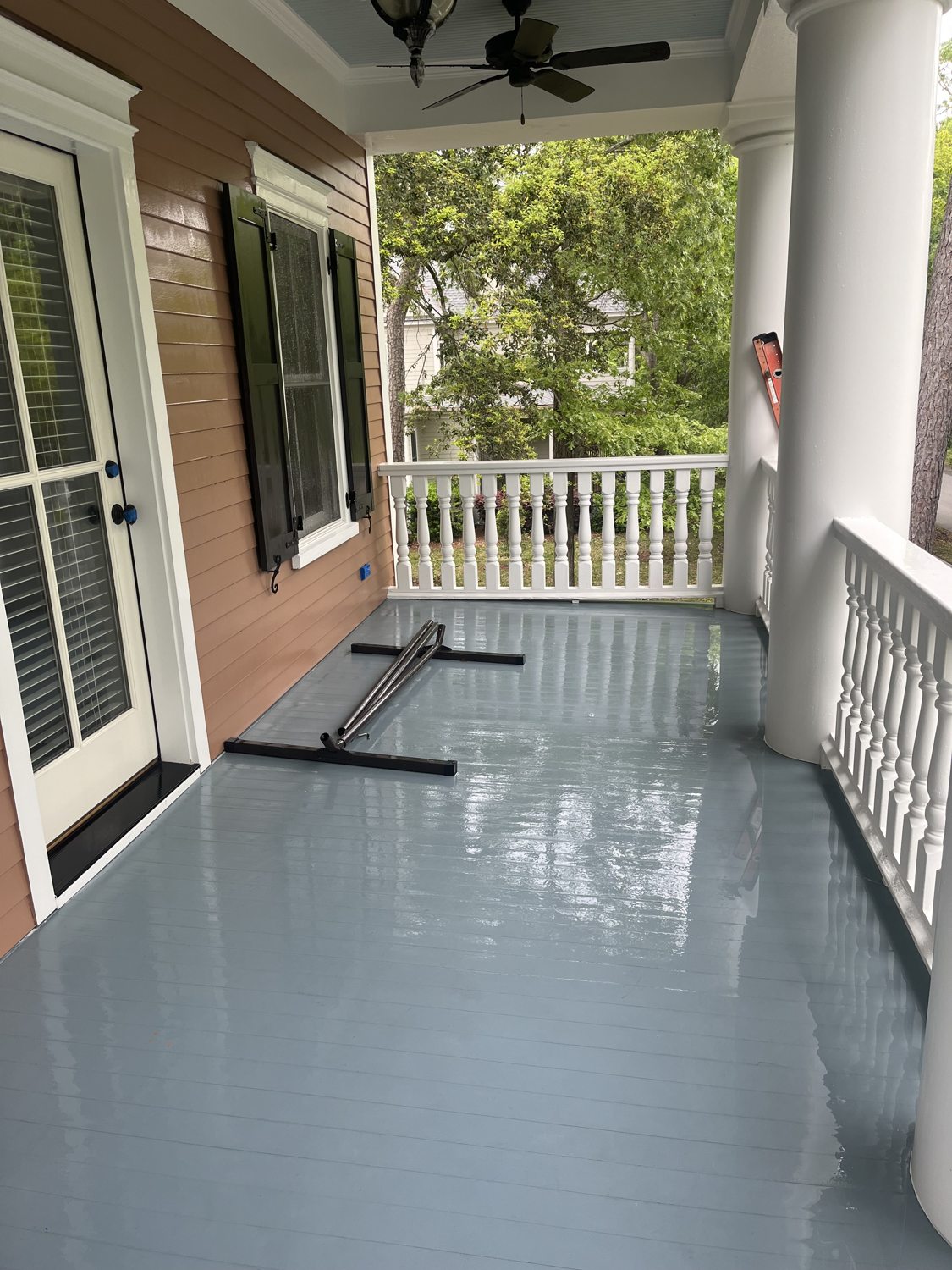 Freshly washed porch decking and white columns, gleaming after a full exterior clean